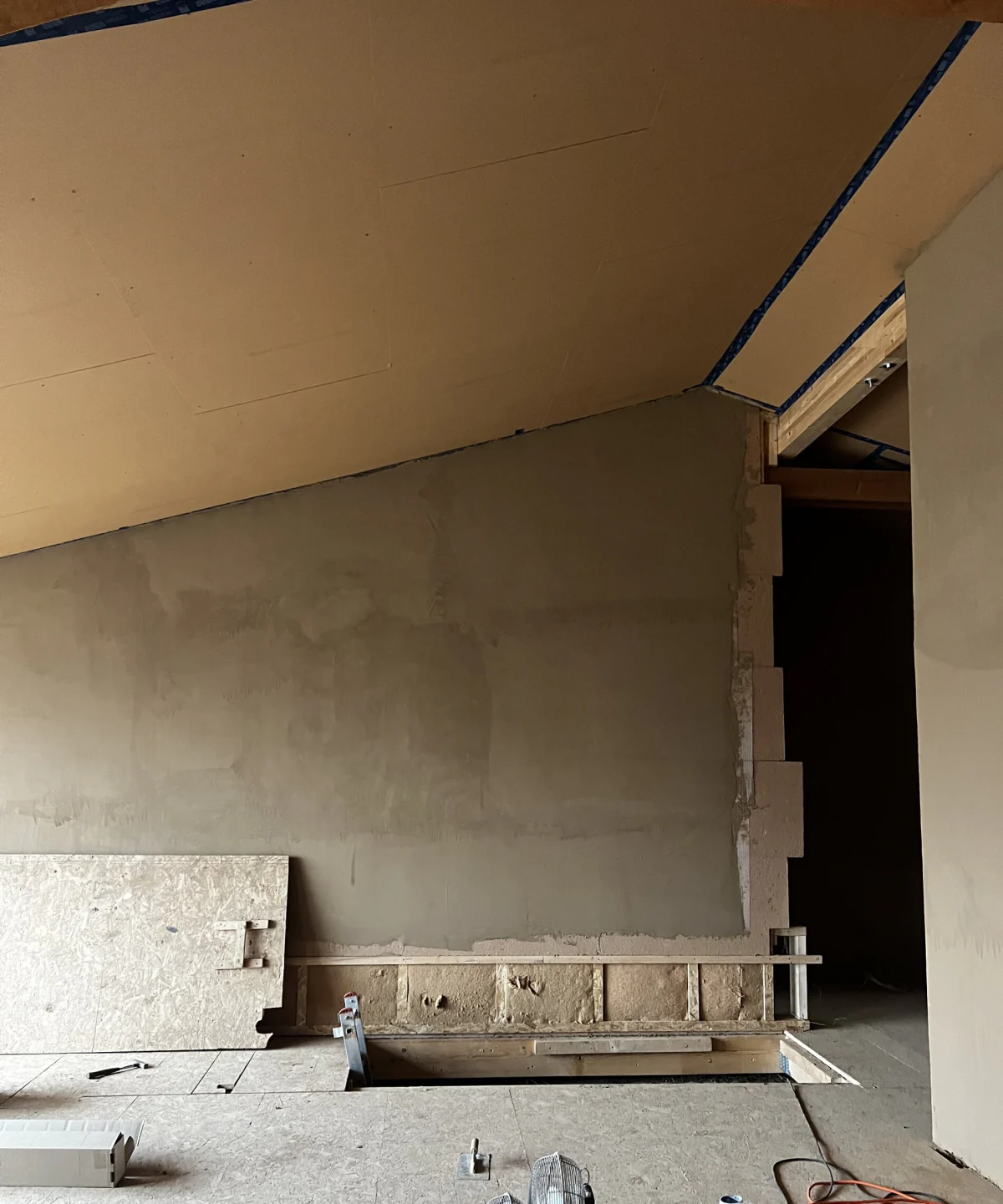 Plastered wall under the roof slope, stair opening below